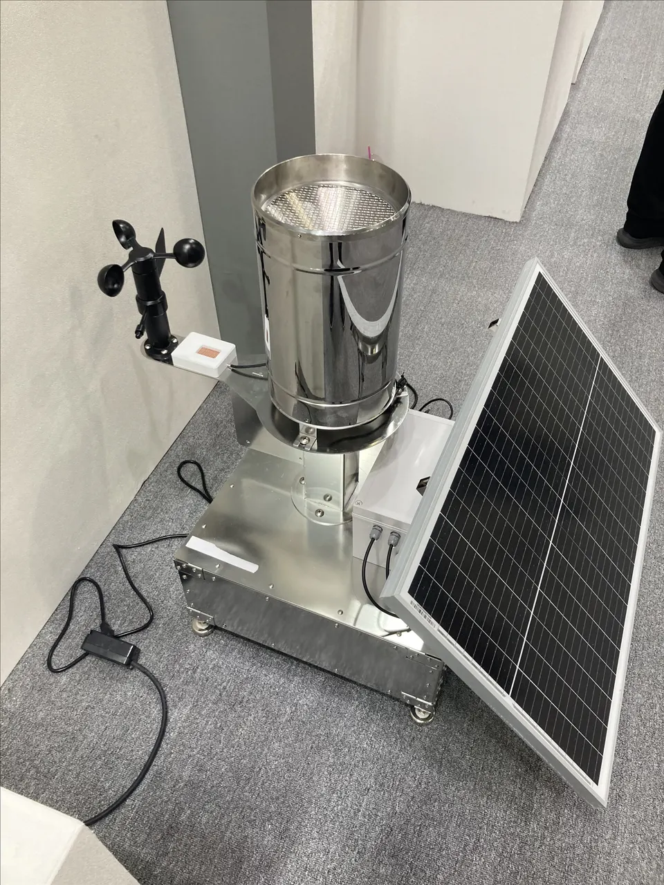 Im Innenraum fotografierter Smart-Regenmesser mit Solarpanel und Windmesser